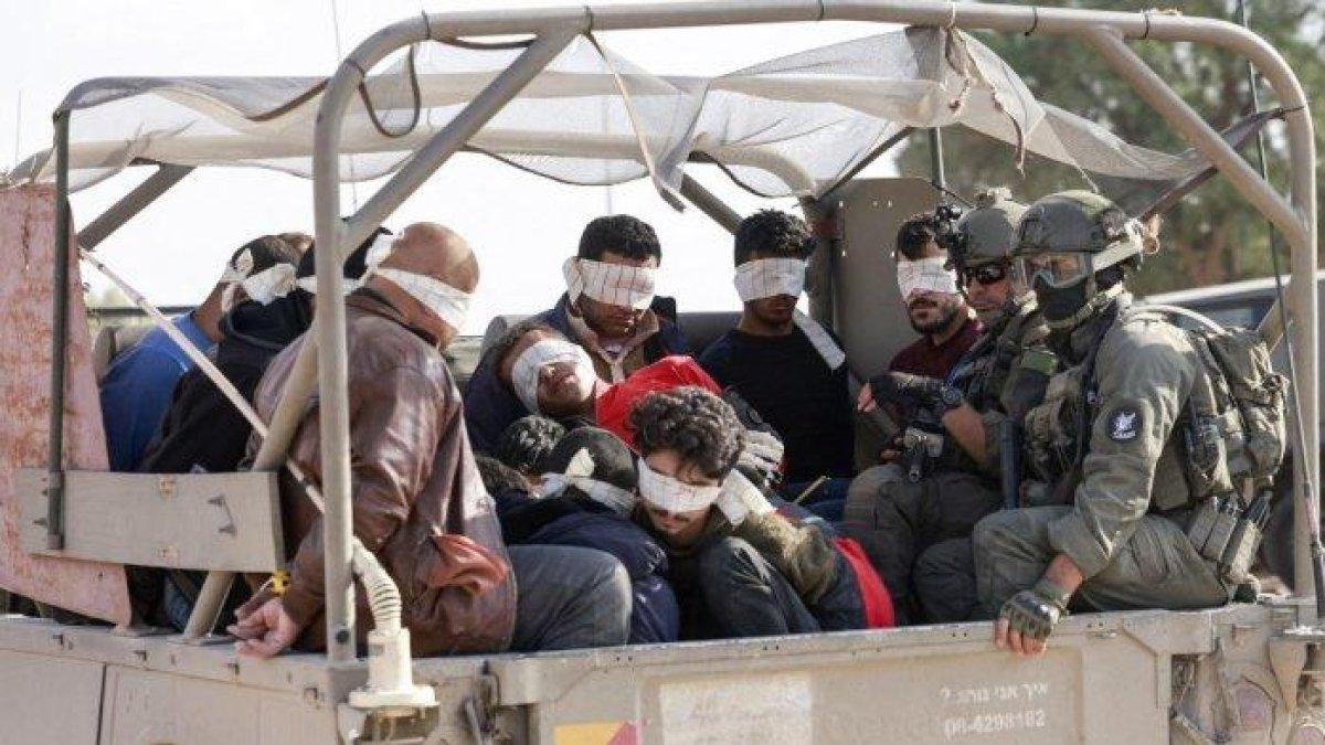 Tentara Israel memindahkan warga Palestina yang ditahan keluar dari Jalur Gaza pada 21 November 2023, di tengah pertempuran yang sedang berlangsung antara Israel dan gerakan Hamas Palestina.