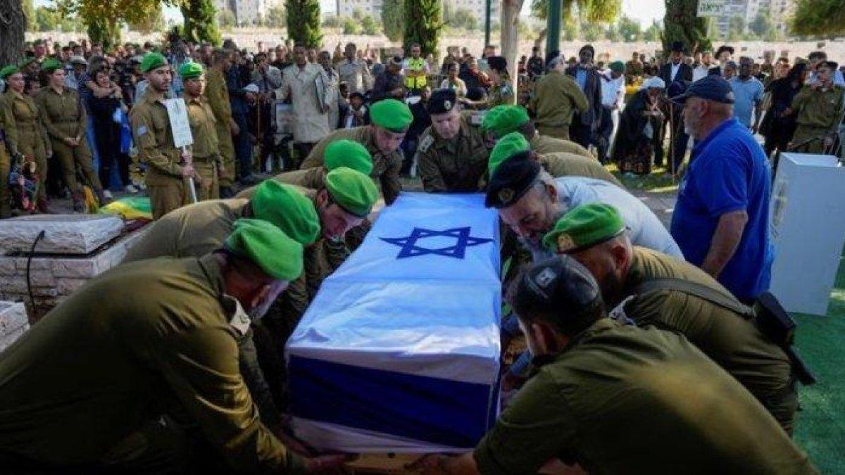 Tentara Israel menurunkan peti mati ke lubang kubur saat memakamkan Staf Sersan Aschalwu Sama, Minggu (3/12/2023).