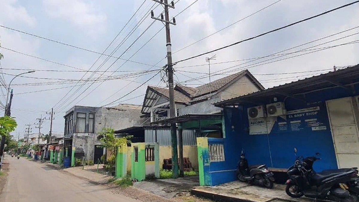 Tiang listrik PLN di dalam teras rumah Sidoarjo yang akan dipindahkan.