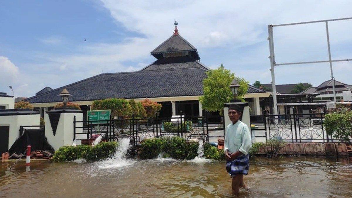 Turmudi tetap berangkat salat di Masjid Demak meski banjir menggenang jalanan.