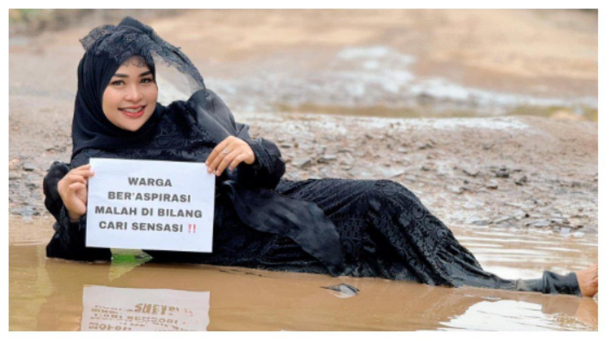 Ia membagikan beberapa foto dan video dirinya berpose dan 'berenang' di dalam lubang jalan rusak.