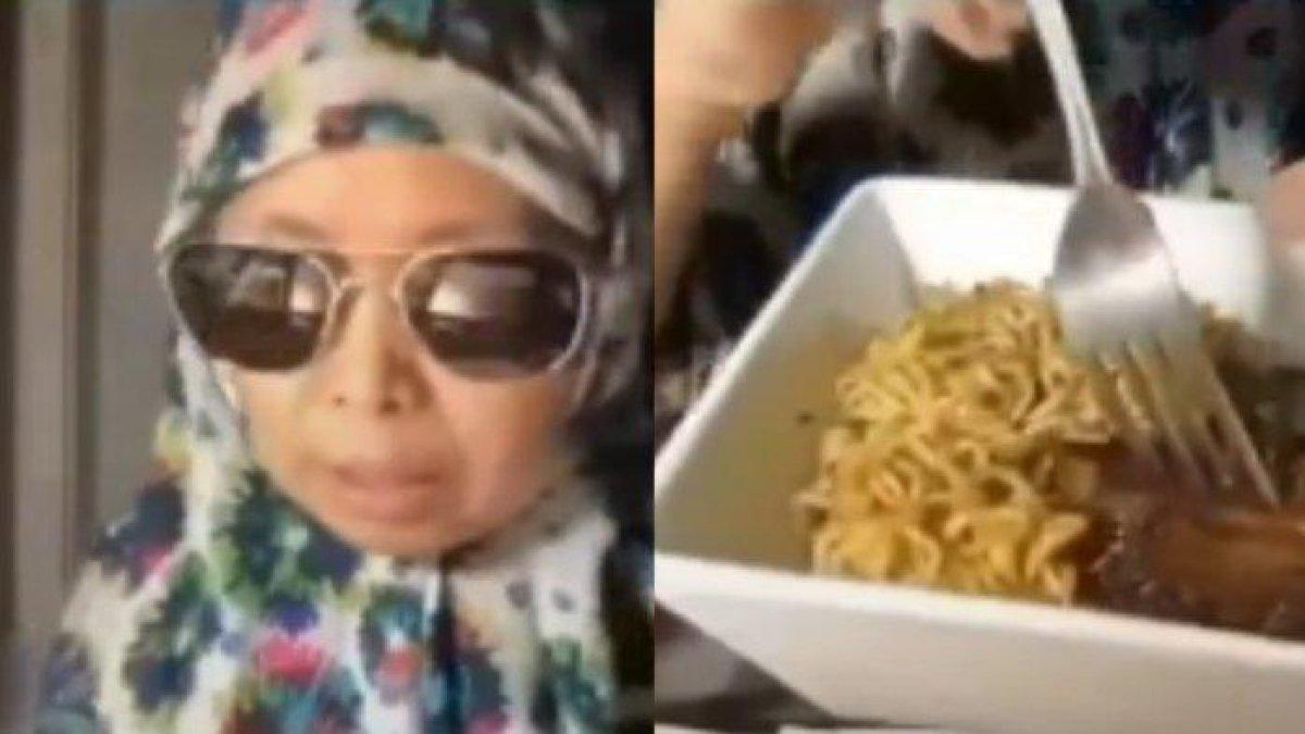 Wanita berkerudung santap mie dengan daging babi
