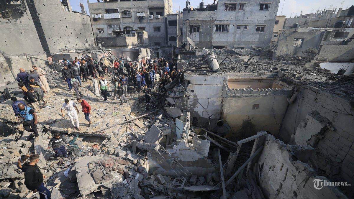Warga Palestina memeriksa kerusakan rumah yang hancur akibat serangan Israel terhadap Khan Yunis di Jalur Gaza selatan pada 1 Desember 2023, setelah berakhirnya gencatan senjata tujuh hari antara Israel dan militan Hamas.