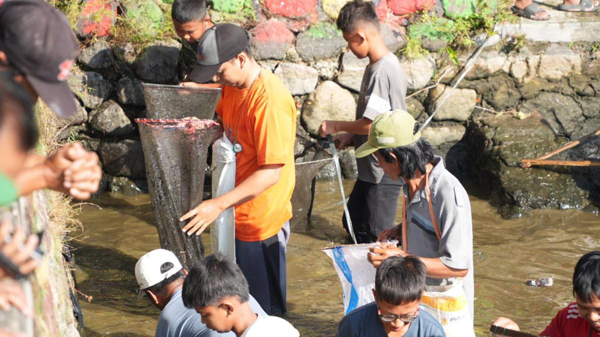FESTIVAL MEMET IKAN - Ribuan warga berebut ikan saat Festival Memet Ikan 2025, di Embung Desa Gemblegan, Kecamatan Kalikotes, Klaten, Minggu (20/7/2025).