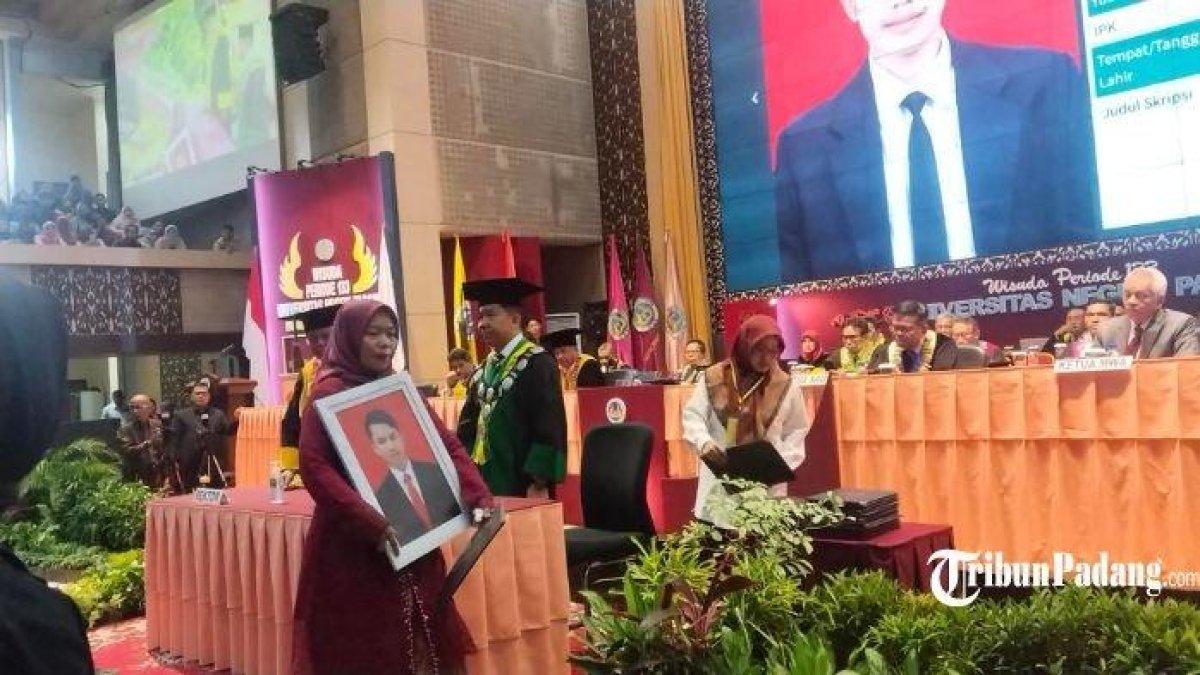 Dengan membawa foto putra sulung tercinta itu, Yanti maju ke area utama di Auditorium UNP menggantikan wisuda sang anak yang jadi korban erupsi Gunung Marapi, Senin (18/12/2023).