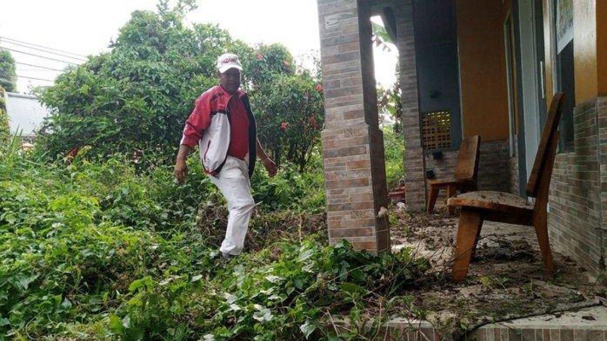 Yosef saat membersihkan rumah yang jadi TKP penghilangan nyawa istri dan anaknya, Tuti Suhartini dan Amalia Mustika Ratu. Kini, dinyatakan menjadi tersangka.