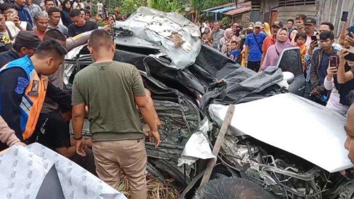 Warga mengevakuasi korban yang terjepit didalam minibus Nissan Juke Silver ringsek dihantam kereta api di perlintasan kereta tanpa plang di Jalan Marah Rusli, Kelurahan Selawan, Kecamatan Kota Kisaran Timur, Kabupaten Asahan.