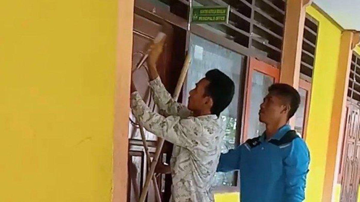 Tangkapan layar video guru dan staf SMPN 2 Monta, Kabupaten Bima saat menyegel ruangan kepala sekolah. Video berdurasi 3 menint 44 detik memperlihatkan ruangan kepala SMPN 2 Monta dipaku menggunakan bilahan bambu.