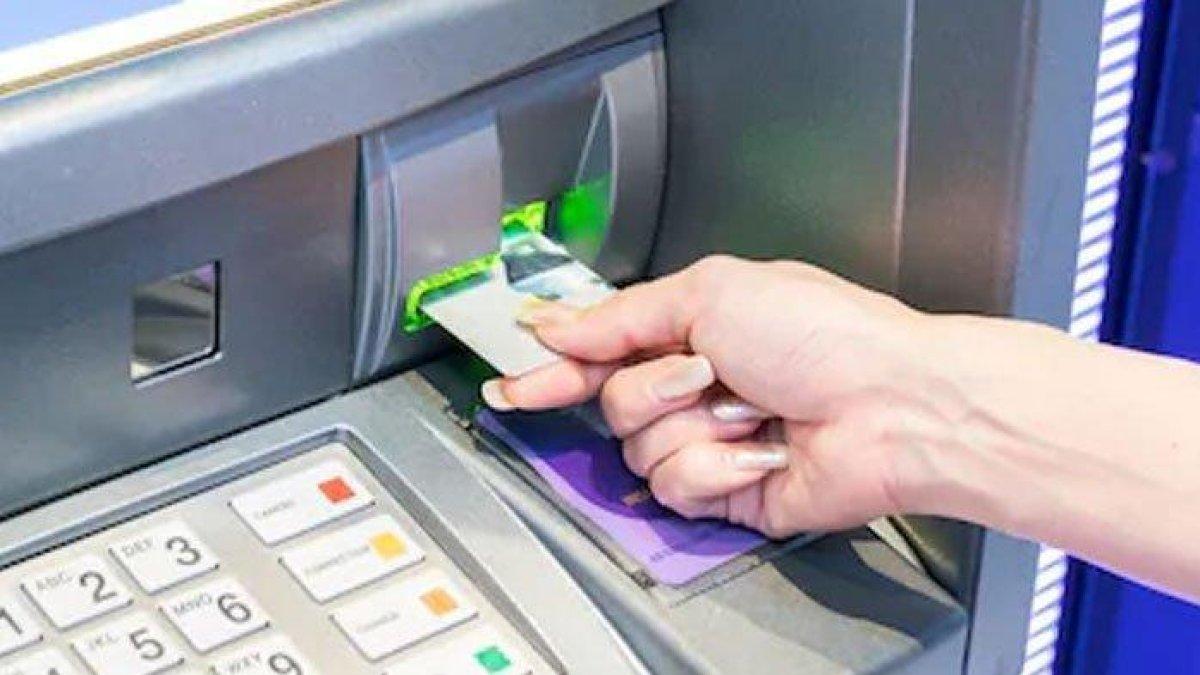 Ilustrasi seseorang tengah mengambil uang di mesin ATM.