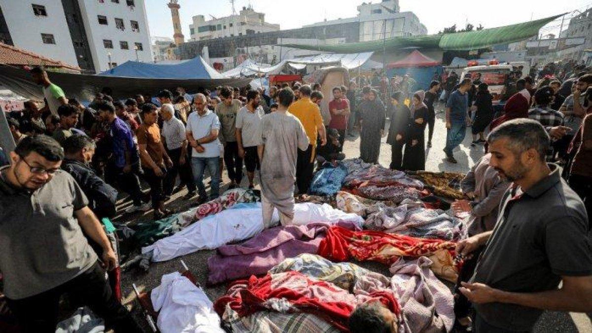 Orang-orang memeriksa jenazah para korban yang tewas dalam pemboman Israel saat mereka terbaring di luar rumah sakit Al-Shifa di Kota Gaza pada 8 November 2023, di tengah pertempuran yang sedang berlangsung antara Israel dan gerakan Hamas Palestina.