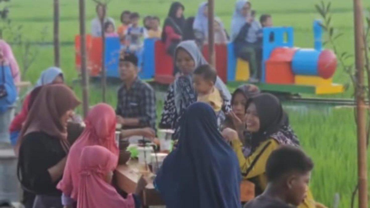 OBYEK WISATA KLATEN: Suasana hangat di Lokamerta Klaten, di mana pengunjung menikmati waktu bersama di area kuliner dengan latar belakang kereta wisata mini yang melintasi hamparan sawah hijau