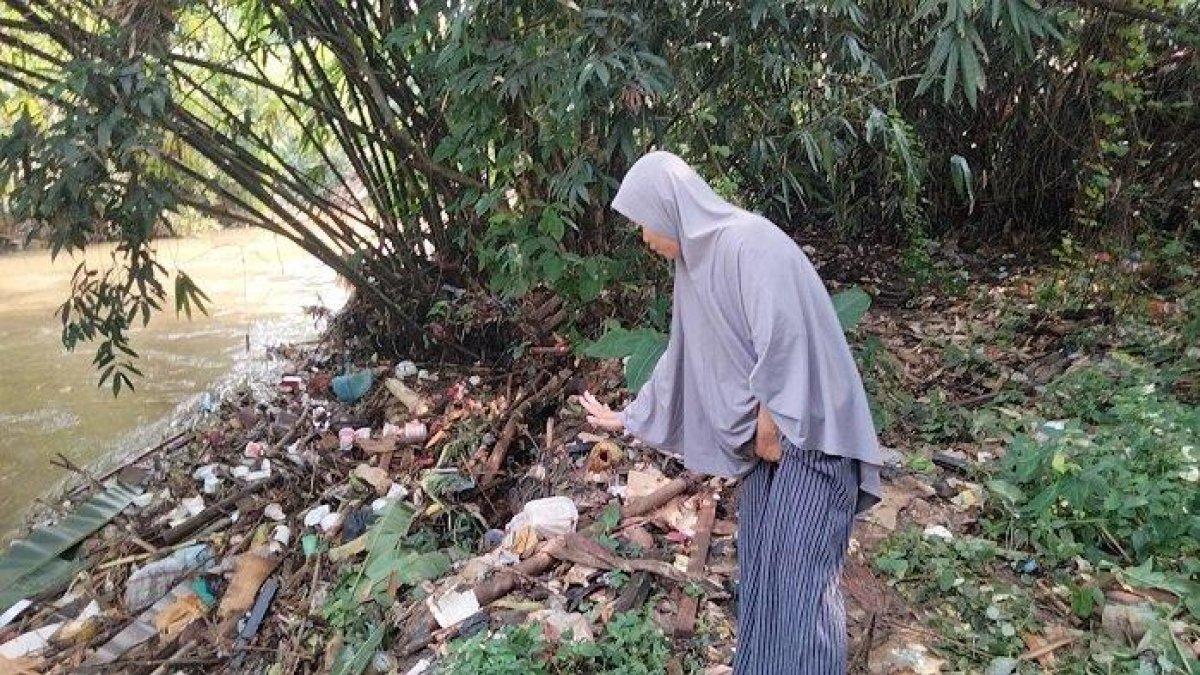 Ketua RT, Sitijaenabun menunjukan lokasi penemuan jasad bayi di pinggiran aliran Kali Baru, Desa Waringin Jaya, Kecamatan Bojonggede, Kabupaten Bogor, Jumat (23/6/2023).