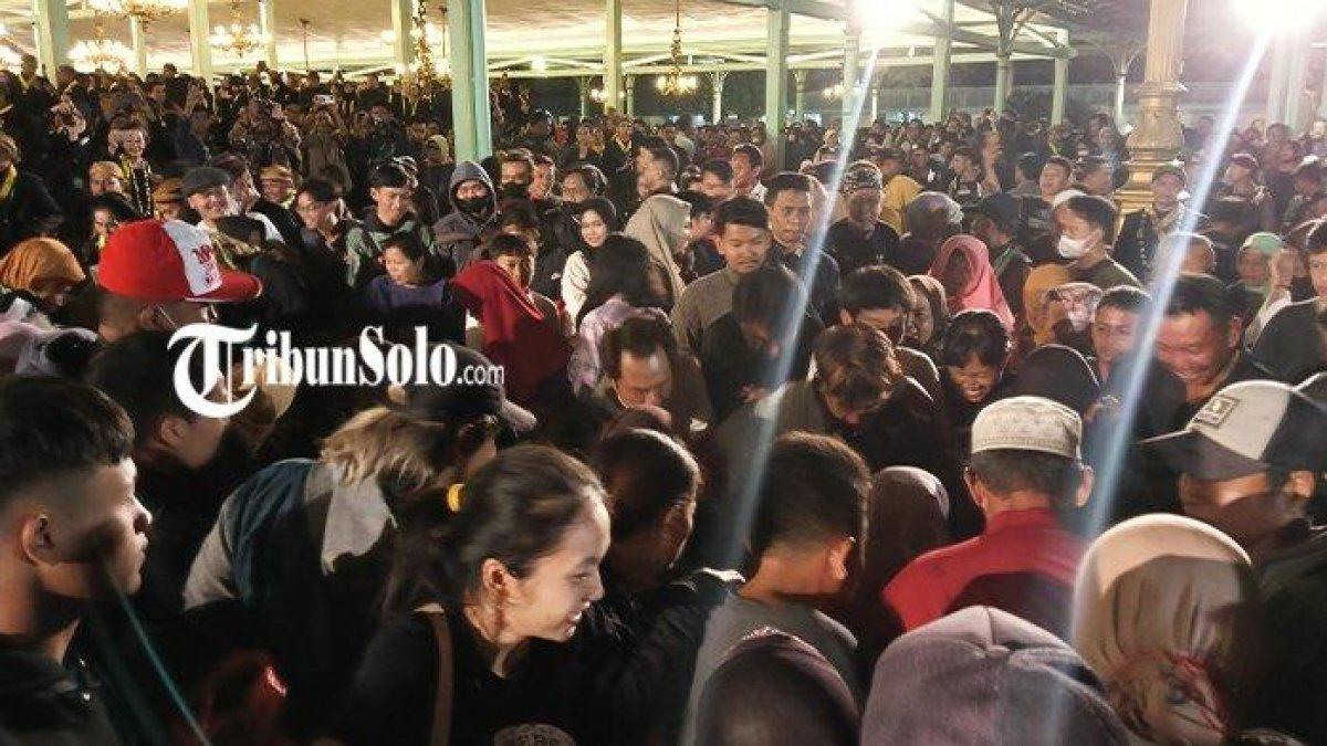 Masyarakat saat berebut dalam tradisi udik-udik di Pura Mangkunegaran, Selasa (18/7/2023)