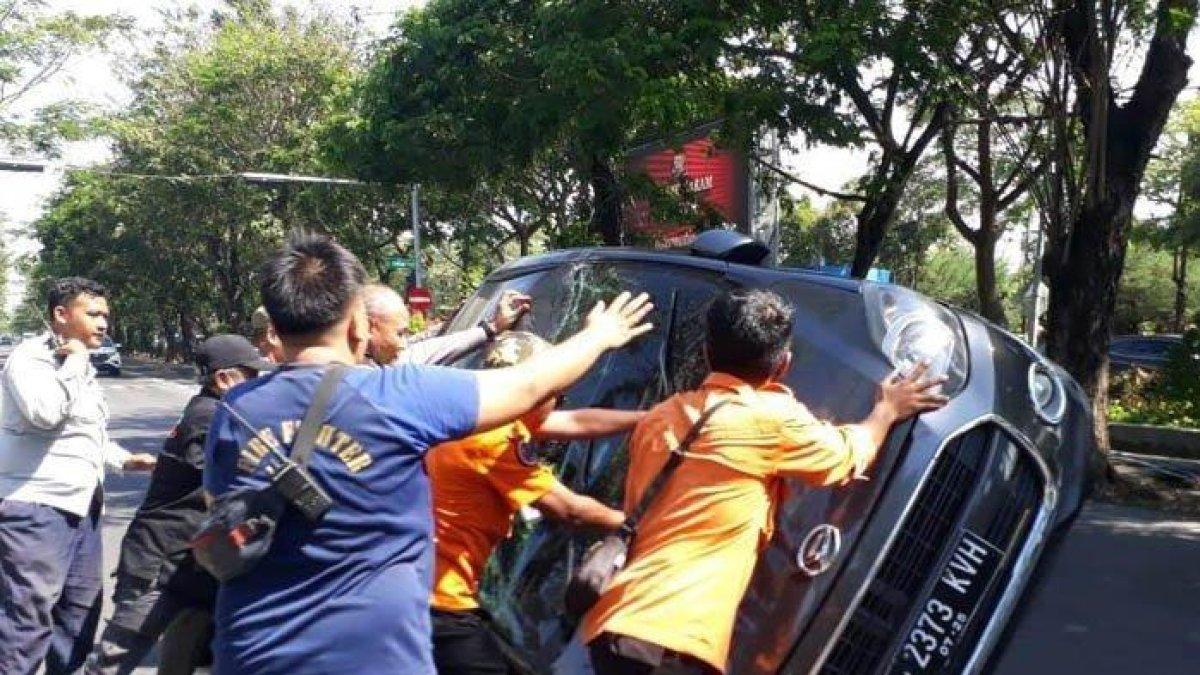 Petugas saat membantu mengevakuasi mobil korban yang terbalik di dekat traffic light (TL) Margorejo, kawasan Jalan Ahmad Yani Surabaya, Sabtu (15/7/2023) siang.
