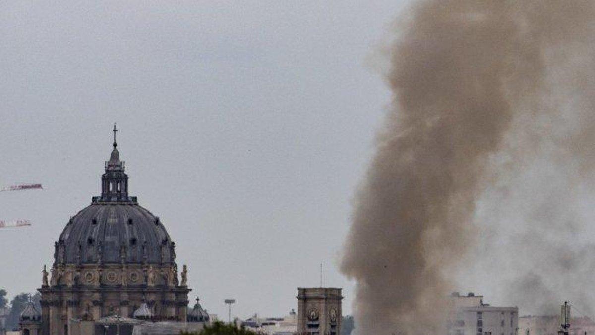 Pandangan umum ini menunjukkan asap mengepul dari sebuah bangunan di Place Alphonse-Laveran dekat kubah Gereja Val-de-Grâce (kiri) di arondisemen ke-5 Paris, pada 21 Juni 2023.