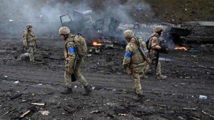 Pasukan keamanan Ukraina berjalan di antara puing-puing akibat serangan militer Rusia untuk mengumpulkan peluru yang tidak meledak di Kyiv, ibu kota Ukraina, Sabtu (26/2/2022). 