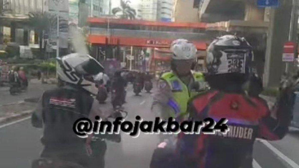 polisi memberhentikan motor relawan pengawal ambulans saat melakukan pengawalan