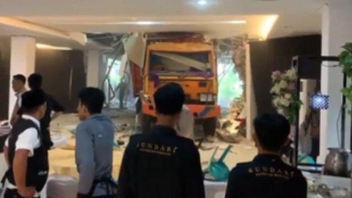 Tamu pesta pernikahan kaget dengan truk menerobos masuk ke gedung pesta. Truk itu menabrak dinding gedung.