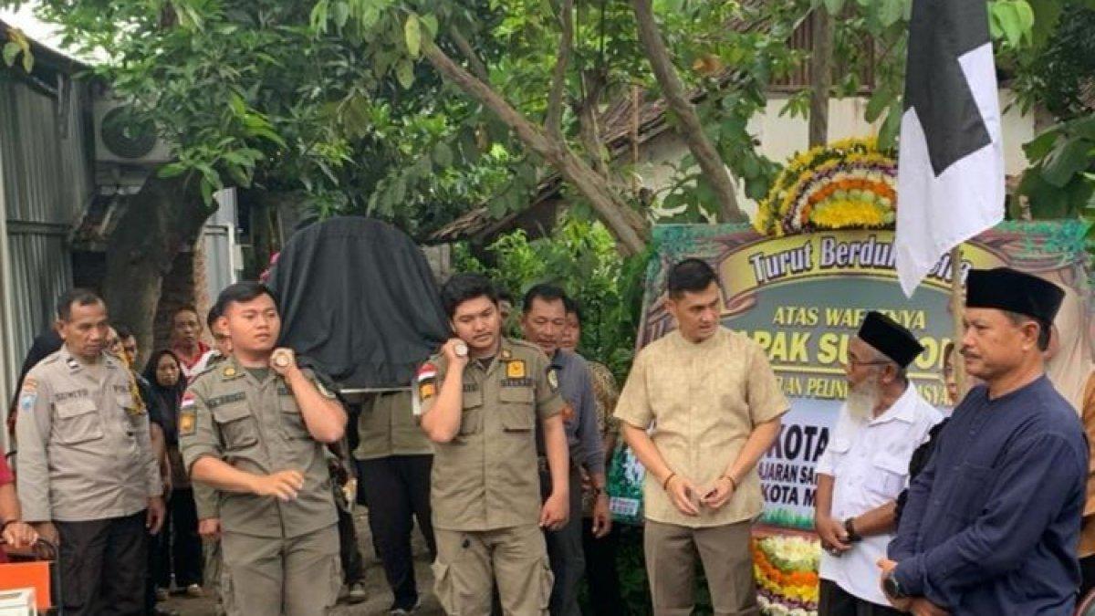 Wali Kota Madiun, Maidi (baju hitam) memimpin jalannya upacara pemakaman almarhum Sugiyono (60), anggota Satlinmas Kota Madiun yang meninggal saat menjalankan tugas di TPS 06, Kelurahan Ngegong, Kecamatan Manguharjo, Kota Madiun, Jawa Timur, Rabu (14/2/2024) petang.