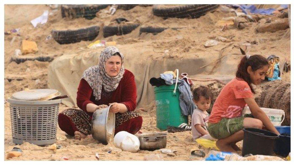 wanita Palestina mencuci peralatan masaknya dengan air laut