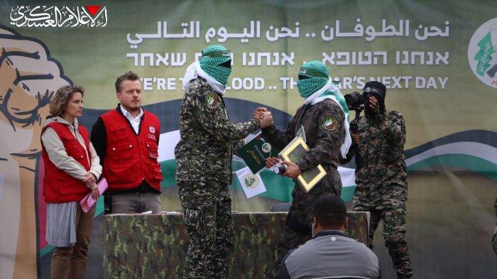 ANGGOTA BRIGADE AL-QASSAM - Foto ini diambil pada Minggu (9/2/2025) dari publikasi resmi Brigade Al-Qassam (sayap militer Hamas) pada Sabtu (8/2/2025), memperlihatkan anggota Brigade Al-Qassam berjabat tangan sebelum menyerahkan berkas kepada Komite Palang Merah Internasional (ICRC) selama pertukaran tahanan ke-5 pada Sabtu (8/2/2025) sebagai bagian dari implementasi perjanjian gencatan senjata Israel-Hamas di Jalur Gaza, dengan imbalan 183 tahanan Palestina.