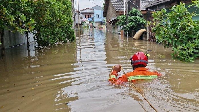 SETINGGI DADA - Petugas mengevakuasi warga Kampung Candulan dan Candiga, Kelurahan Petir, Kecamatan Cipondoh, Kota Tangerang, Banten, yang terendam banjir menggunakan perahu kecil, Selasa (4/3/2025). 