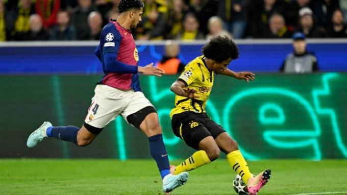 BERDUEL - Aksi bek Barcelona, Ronald Araujo (kiri) saat berduel dengan winger Borussia Dortmund, Karim Adeyemi (kanan) pada pertandingan leg kedua babak 8 besar Liga Champions di Signal Iduna Park, Rabu (16/4/2025) dini hari WIB.
