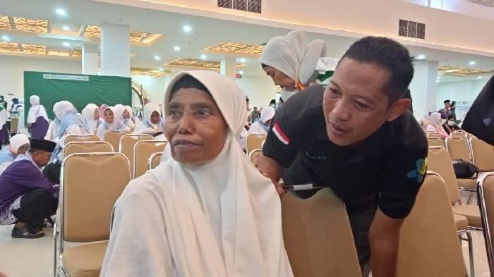 CERITA HAJI 2025 - Seorang JCH asal Lombok Timur Nurseh saat ditenangkan oleh petugas haji di Asrama Haji Embarkasi Lombok karena menangis minta pulang, Minggu (4/5/2025) malam.