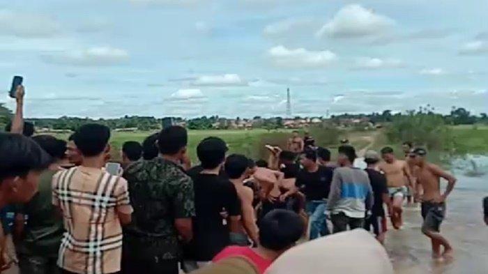 Personel BPBD Ogan Ilir dibantu warga mengevakuasi jasad dua bocah yang tenggelam di rawa lebak wilayah Desa Seri Bandung, Minggu (26/1/2025).