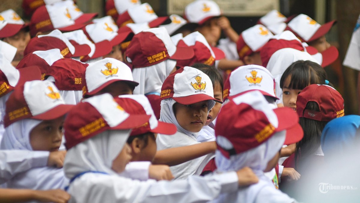 HARI PERTAMA SEKOLAH - Siswa baru mengikuti upacara bendera saat hari pertama masuk sekolah pada tahun ajaran baru 2025-2026 di SDN 2 Kebonsari Kota Malang, Jawa Timur, Senin (14/7/2025). Hari pertama masuk sekolah siswa baru diajarkan Masa Pengenalan Lingkungan Sekolah (MPLS) dengan berbagai kegiatan yakni pembagian kelompok, sosialisasi tata tertib sekolah, penjelasan jadwal dan kegiatan MPLS, serta latihan upacara pembukaan MPLS. TRIBUN JATIM/PURWANTO