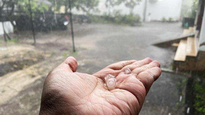 HUJAN ES JOGJA - Seorang warga mengabadikan butiran es yang jatuh di daerah Ngaglik, Sleman pada Selasa (11/3/2025).