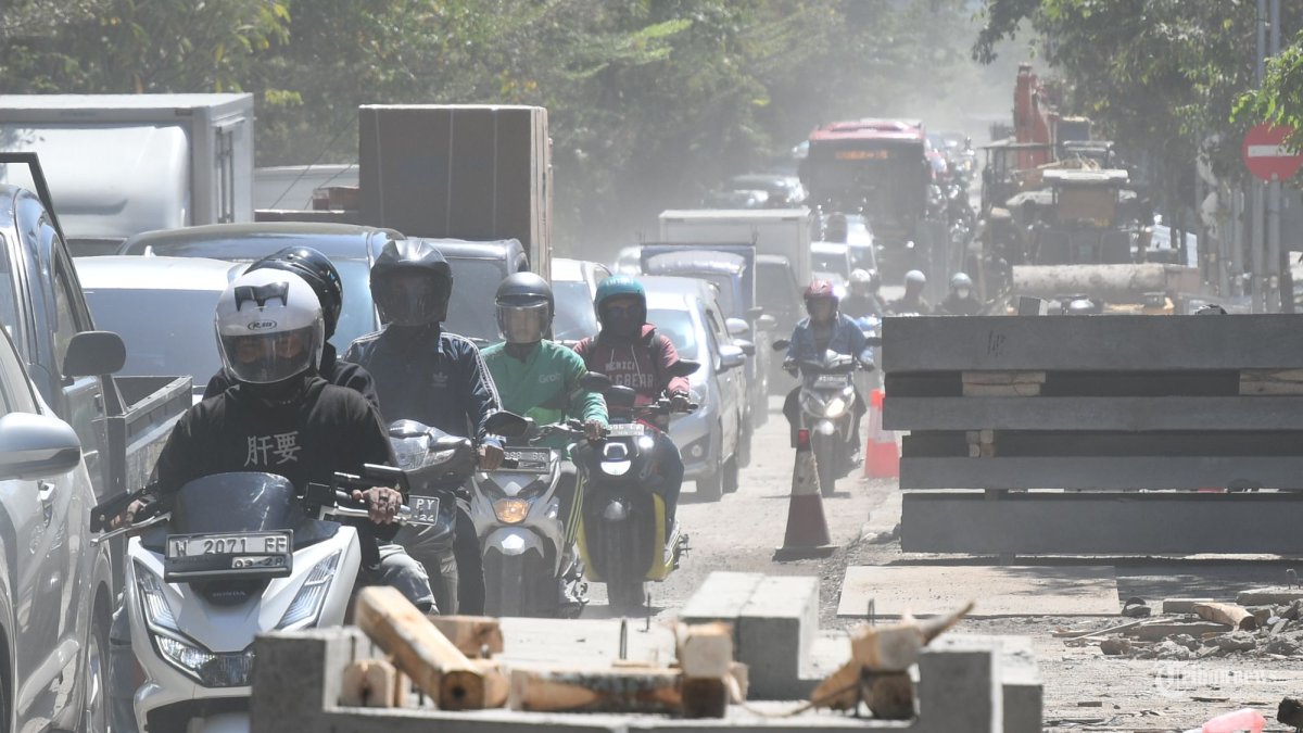PADAT & BERDEBU - Antrian kendaraan dari arah barat (Surabaya Barat) terlihat mengular saat melintasi Jl Mayjen Sungkono (sisi utara) Surabaya, Rabu (11/9/2024). Kondisi jalanan yang menyempit dan berdebu ini dampak dari adanya pengerjaan proyek saluran air (crossing saluran) dan diberlakukan rekayasa lalu lintas saat pengerjaan di malam hari. (SURYA/HABIBUR ROHMAN)  