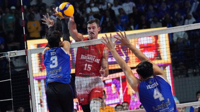 PROLIGA 2025 - Pevoli Bhayangkara Presisi, Kyle Russell (tengah) melakukan spike dan diadang pevoli putra LavAni, Boy Arnez Arabi dalam pertandingan Grand Final Proliga 2025 di Gor Amongrogo, Yogyakarta pada Minggu (11/5/2025).
