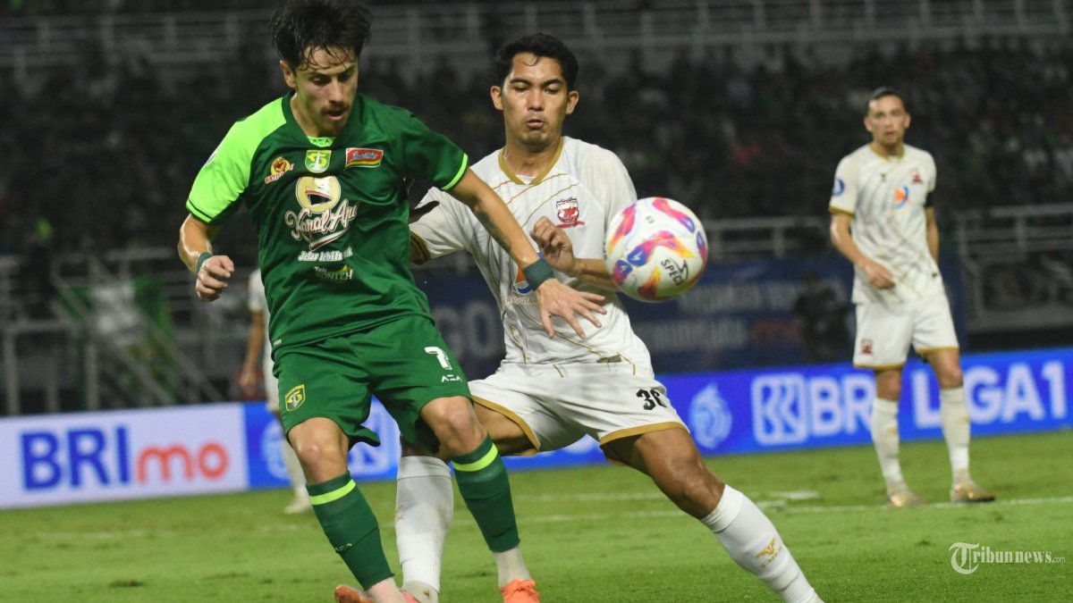 MENANG TIPIS - Pemain Persebaya Rivera(kiri) berebut bola dengan pemain Madura United Ilhamsyah (kanan) pada laga yang berlangsung di Stadion Gelora Bung Tomo (GBT) Surabaya, Minggu (20/4/2025). Pada pertandingan Liga-1 musim 2024/2025 Matchday ke-29 ini Persebaya sebagai tuan rumah berhasil mengungguli tim tamu Madura United dengan skor akhir 1-0. (SURYA/HABIBUR ROHMAN)