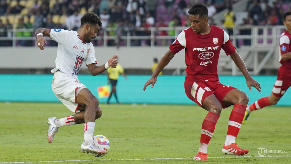 MENGGIRING BOLA - Pesepak bola Malut United, Yakob Sayuri (kiri) menggiring bola dan diadang pesepak bola Persis Solo, Jose Cleylton Santos (kanan) dalam pertandingan Liga 1 di Stadion Manahan, Solo, Sabtu(12/4/2025) sore. Malut United menang 3-1 atas Persis Solo berkat hattrick Yakob Sayuri. Tribun Solo/Muhammad Nursina