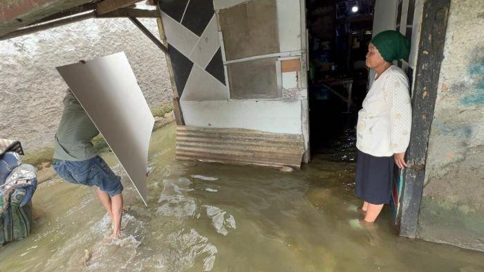DAPAT BANTUAN PRESIDEN - Nenek Mardasih, warga Kampung Tambun Inpres, Desa Buni Bakti, Kecamatan Babelan, Kabupaten Bekasi di depan rumahnya yang tergenang banjir, Minggu (9/3/2025). Mardasih mendapat bantuan untuk merenovasi rumah dari Presiden Prabowo.