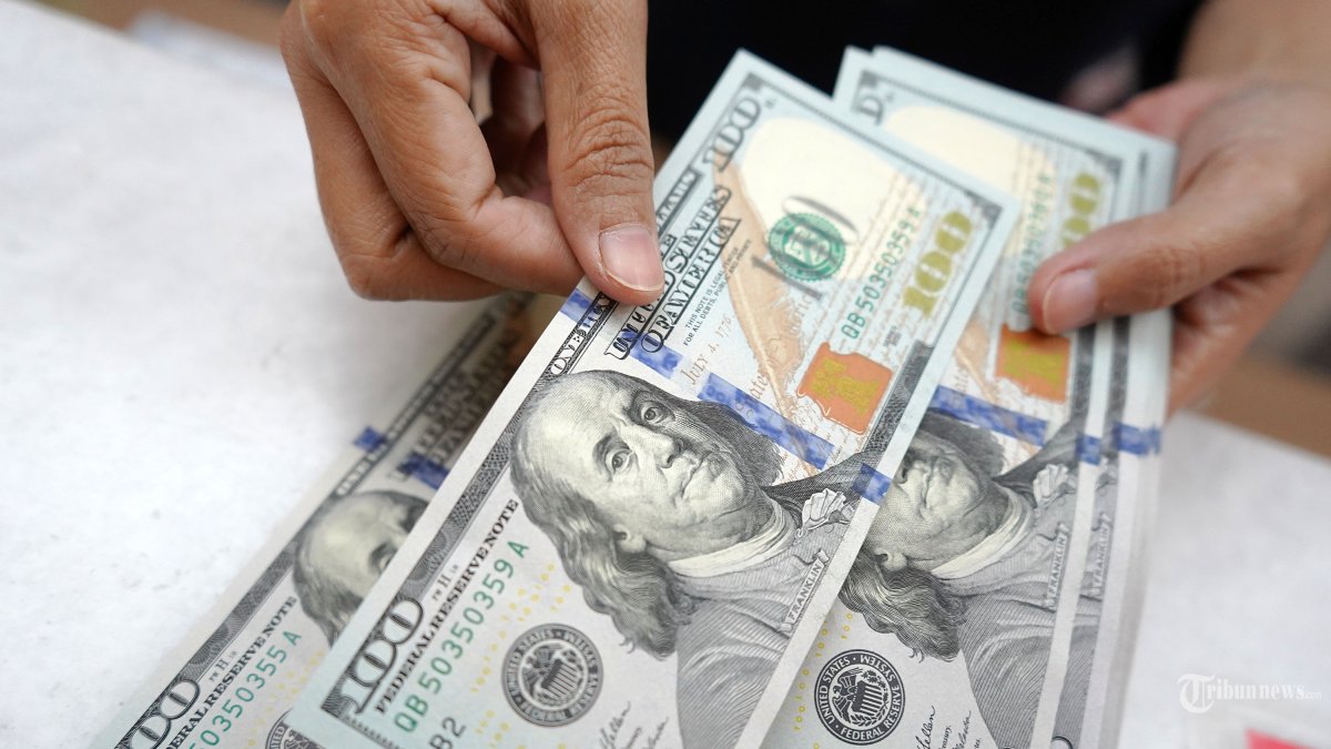 NILAI TUKAR RUPIAH - Petugas menunjukan uang pecahan dolar AS di gerai penukaran mata uang asing Ayu Masagung, Jakarta Pusat, Senin, (8/4/2025). Nilai tukar rupiah terhadap dolar AS pada hari ini dibuka pada posisi Rp 16.850 per Dolar AS atau melemah 1,78 persen. Usai libur Lebaran Idulfitri 1446 H. Ambrolnya rupiah ini disebabkan oleh sejumlah sentimen yang datang dari global, utamanya kebijakan tarif Donald Trump. Tribunnews/Jeprima