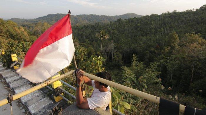 PASANG BENDERA - Seorang sopir truk memasang bendera merah putih di atas armadanya saat beristirahat di kawasan Jalan Samboja-Semoi, Bukit Bengkirai, Kecamatan Samboja, Kutai Kartanegara, Kalimantan Timur, Senin (26/8/2019).