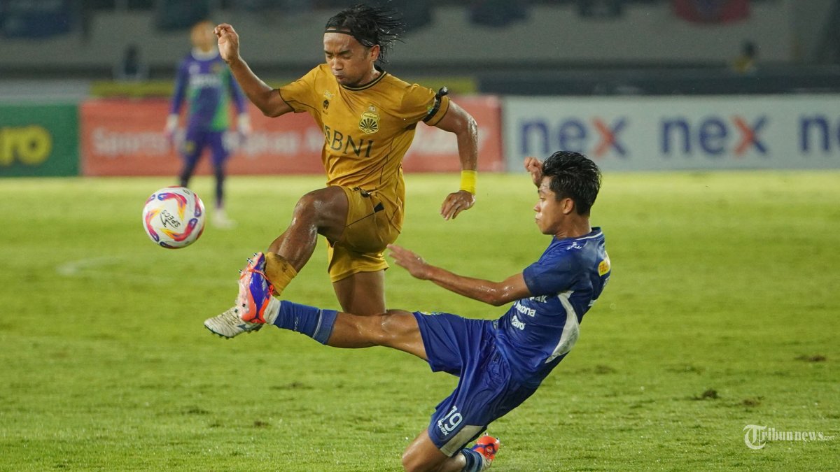 BEREBUT BOLA - Pesepak bola PSIM Yogyakarta, Figo Dennis melakukan tekel (kanan) kepada pesepak bola Bhayangkara FC, Taufiq Febriyanto pada pertandingan final Liga 2 2024/2025 di Stadion Manahan, Solo, Rabu (26/2/2025) sore. PSIM berhasil keluar sebagai juara setelah mengalahkan Bhayangkara dengan skor 2-1. Tribun Solo/Muhammad Nursina