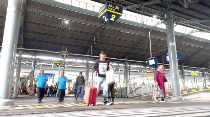 Para penumpang menyeberang rel setelah tiba di Stasiun Solo Balapan, Senin (9/12/2024)