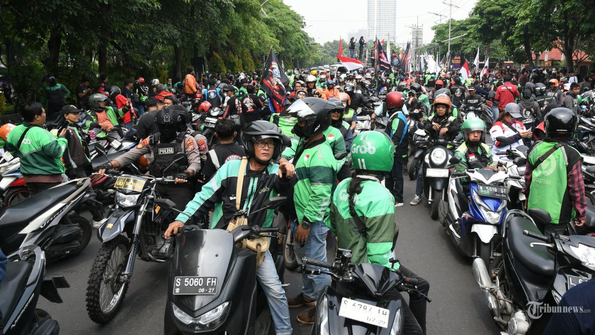 PEMKOT TANGGUNG BPJS - Driver ojek online pada aksi di kota Surabaya beberapa waktu lalu. Pemkot Surabaya  memperluas jaminan perlindungan kepada warga kota Surabaya melalui kepesertaan di BPJS Ketenagakerjaan dan kali ini  menyasar pada driver ojek online di Kota Pahlawan. (SURYA/HABIBUR ROHMAN)