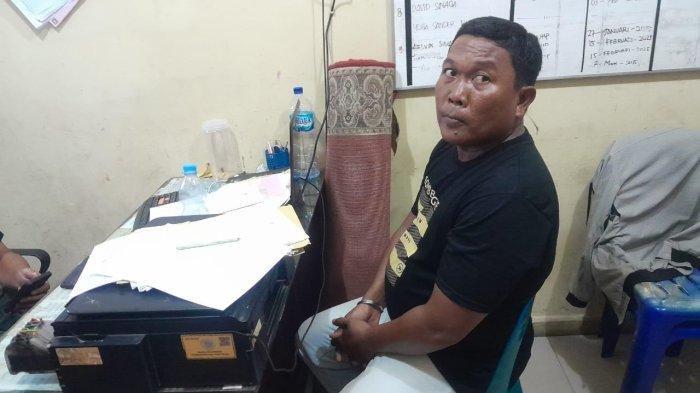 PENJAGA KONTER DIANIAYA - Tersangka Adelan Perdana (37) saat diamankan di Mapolsek Medan Area usai melakukan penganiayaan yang sempat viral di media sosial. Barang bukti berupa kayu dan kursi plastik turut disita polisi.