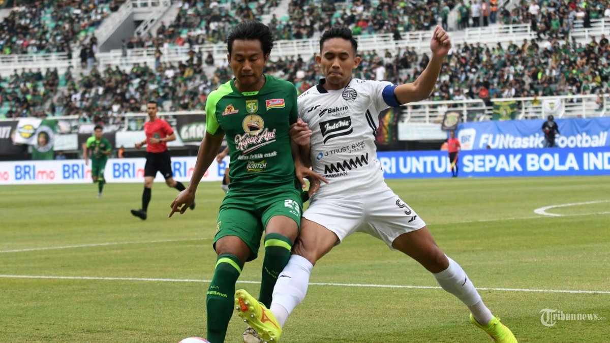 KERJA KERAS - Pemain Persebaya Kadek Raditya (kiri) berebut bola dengan pemain Persija R Ridho (kanan) pada pertandingan antara Persebaya melawan  Persija di Stadion Gelora Bung Tomo (GBT) Surabaya, Jumat (22/11/2024). Pada pertandingan Liga 1 musim 2024/2025 ini Persebaya berhasil menang melawan Persija dengan skor 2-1. (SURYA/HABIBUR ROHMAN) 