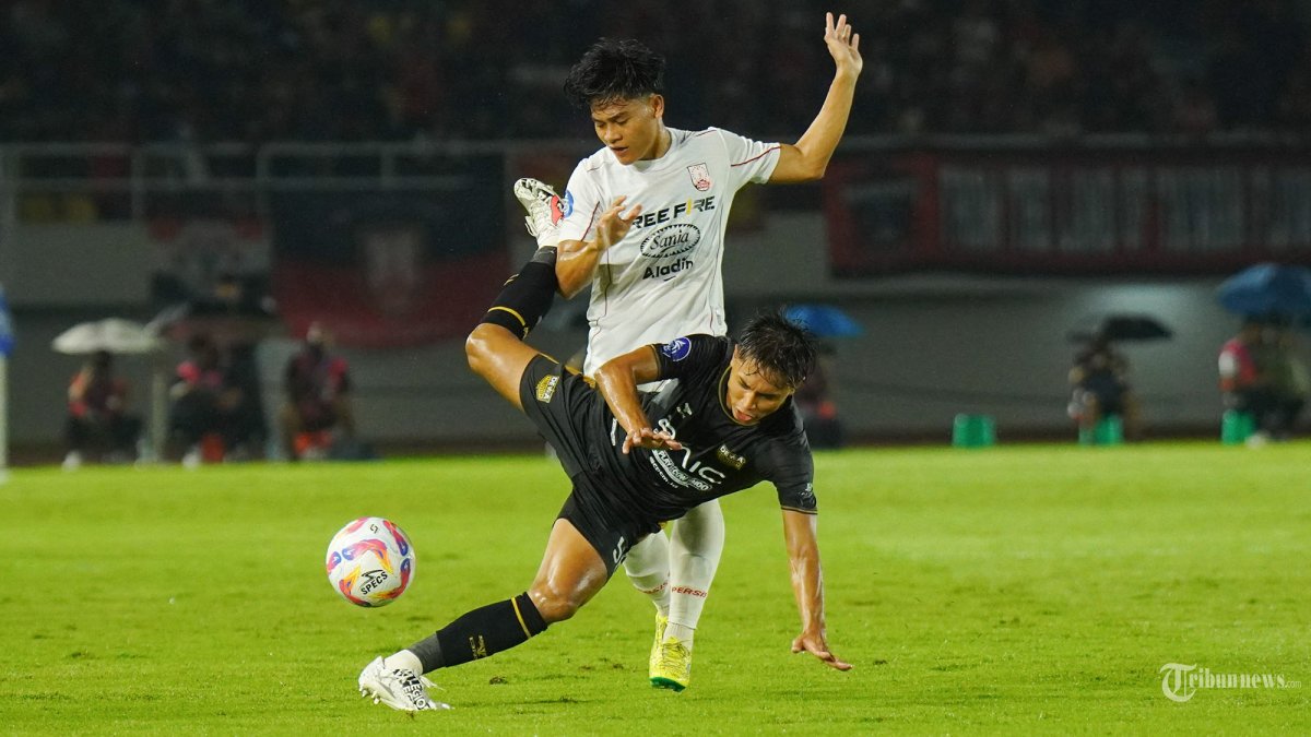 LOLOS DEGRADASI - Pesepak bola Dewa United, Alfriyanto Nico (bawah) berebut bola dengan pesepak bola Persis Solo, Zanadin Fariz dalam pertandingan Liga 1 di Stadion Manahan, Solo, Sabtu (17/5/2025) malam. Laga tersebut berakhir imbang 1-1 dan Persis Solo dipastikan lolos degradasi. (Tribun Solo/Muhammad Nursina)