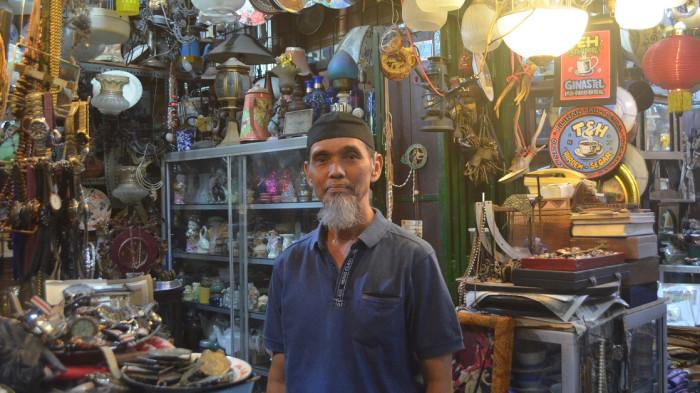 PASAR TRIWINDU - Potret Yoyok (60) yang berjualan barang antik sejak tahun 1990 di kios Pasar Triwindu Solo ketika berada di kiosnya, Selasa (15/7/2025). (Foto: Mg/Rohmah Tri Nosita).