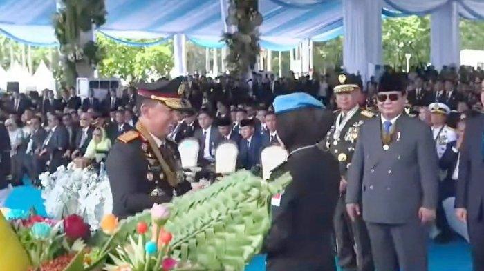 POLISI BERPRESTASI - Momen saat Kapolri Listyo Sigit Prabowo memberikan tumpeng kepada Brigpol Tiara Nisa Zulbida saat Peringatan Hari Bhayangkara 2025, di Monas, Jakarta Pusat, Selasa (1/7/2025).