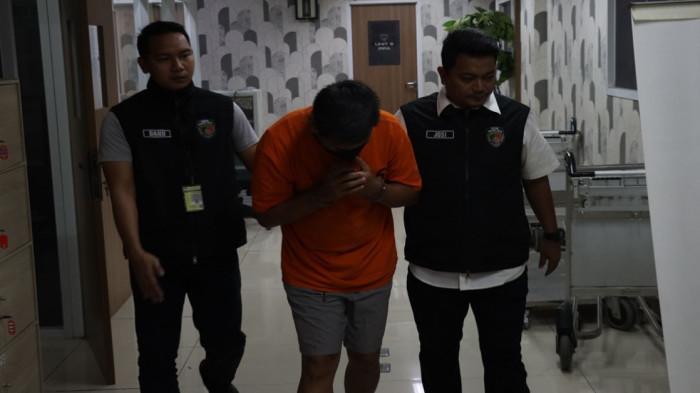 PELECEHAN SEKSUAL -  IM (50) tersangka kasus pelecehan seksual terhadap anak di bawah umur saat digelandang ke rumah tahanan negara (Rutan) Polresta Bandara Soetta, Rabu (16/7/2025).
