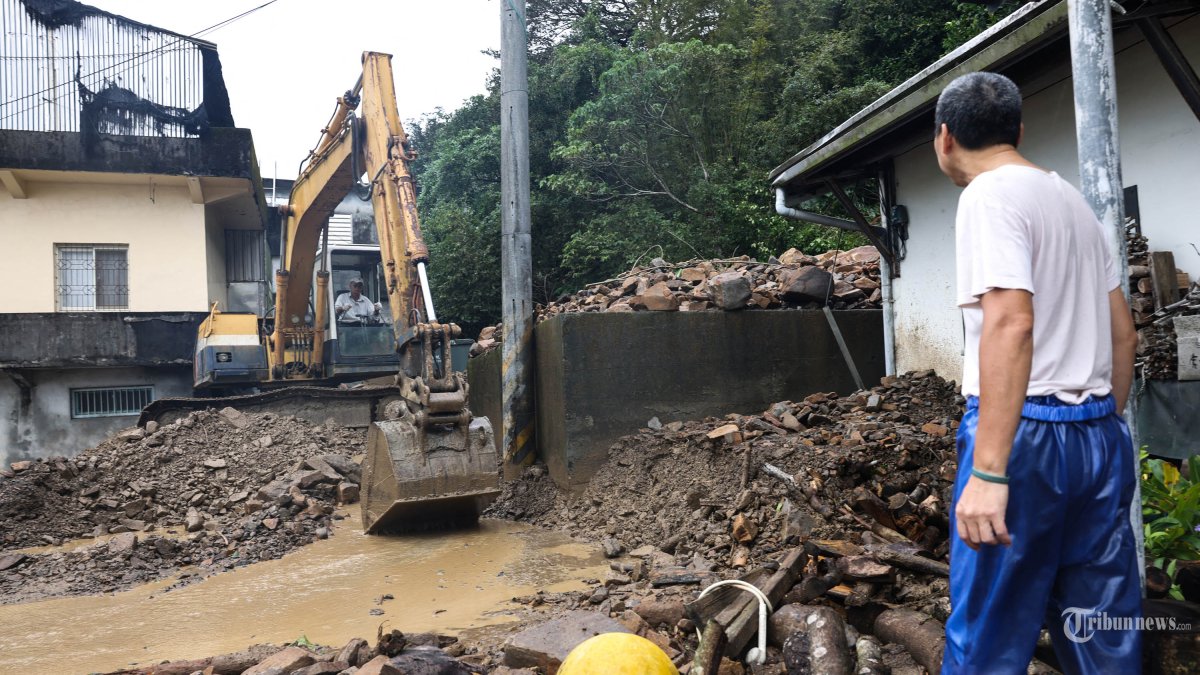 Warga Wu Hsuan-kai (kanan) melihat rumahnya yang rusak akibat tanah longsor akibat topan Kong-rey di Yilan pada tanggal 1 November 2024. (ARSIP, 2024)
