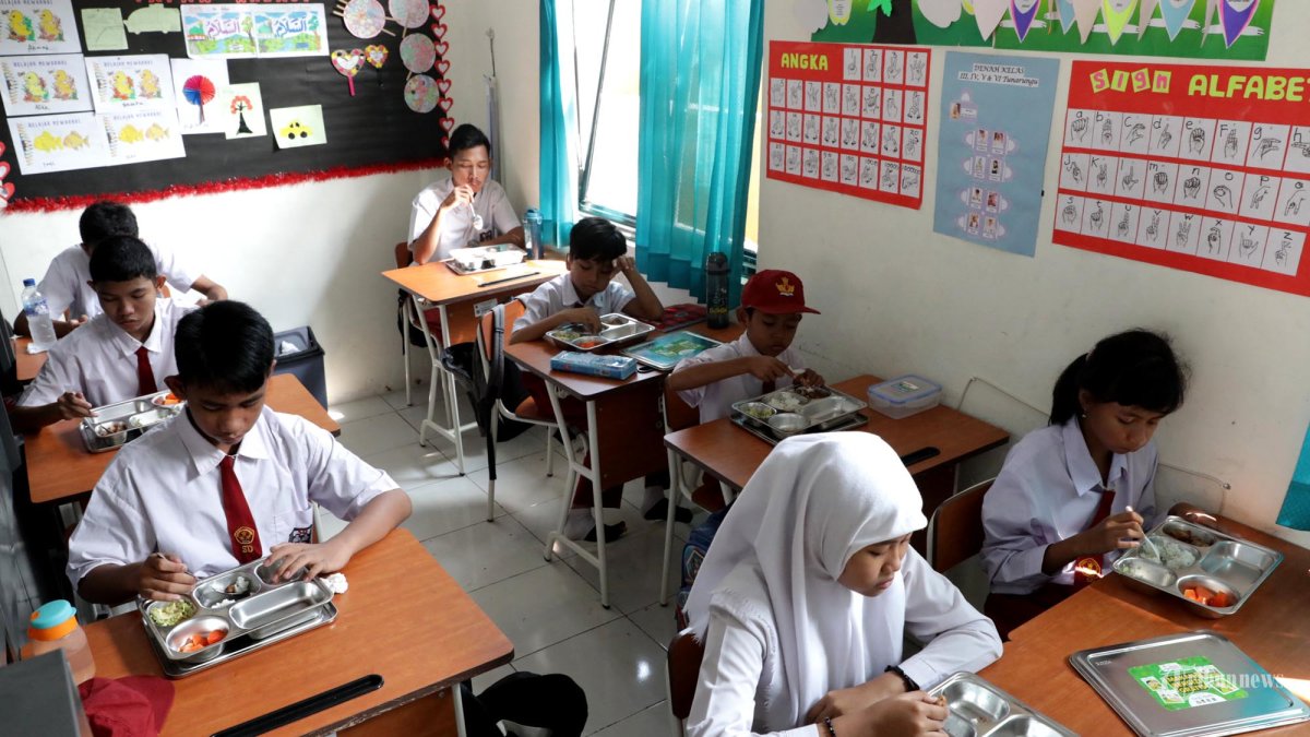 MAKAN BERGIZI GRATIS - Murid berkebutuhan khusus menyantap makanan saat pelaksanaan makanan bergizi gratis (MBG) di Sekolah Khusus Negeri 01 Tangsel, Pondok Kacang, Tangerang Selatan, Banten, Senin (28/4/2025). Yayasan Inklusi Pelita Bangsa (YIPB) bekerja sama dengan OVO dan Grab Indonesia meluncurkan program Makan Bergizi Gratis (MBG) di 11 sekolah khusus se-Tangerang Raya untuk mewujudkan pendidikan inklusif dan pemenuhan gizi bagi anak-anak berkebutuhan khusus. TRIBUNNEWS/IRWAN RISMAWAN