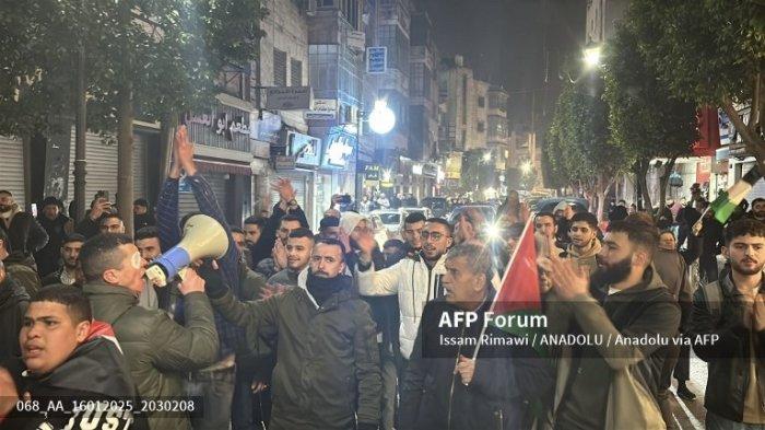 Warga Palestina berkumpul untuk merayakan pengumuman kesepakatan gencatan senjata antara Israel dan Hamas di Ramallah, Tepi Barat pada 15 Januari 2025. Presiden terpilih AS Donald Trump pada hari Rabu mengumumkan kesepakatan telah dicapai untuk para sandera di Gaza di tengah laporan media bahwa Israel dan Hamas menyetujui kesepakatan gencatan senjata. Issam Rimawi / Anadolu